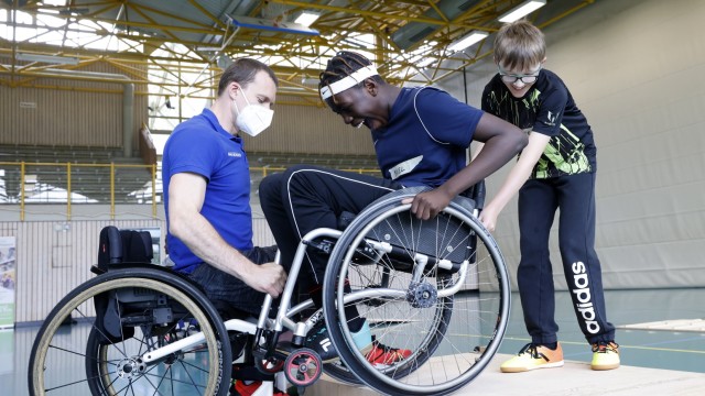 Inklusionstag in Hallbergmoos: Ganz vorsichtig, unterstützt von Paralympics-Teilnehmer André Bienek (l.), geht es mit dem Rollstuhl eine Stufe hinunter.