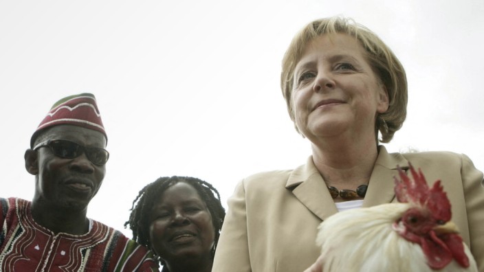 Bundestag: Ein Huhn als Präsent braucht nicht jeder, eine Uhr schon eher. Angela Merkel mit ihrem Gastgeschenk.