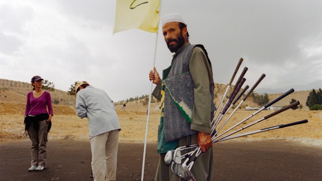 Reisebuch "Finding Afghanistan": Golf spielen im Kriegsgebiet: NGO-Mitarbeiter mit afghanischem Caddy, Qargha, 2004.