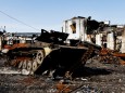 Dmitro, 29, walks past a destroyed Russian army vehicle, amid Russia's invasion of Ukraine, in Trostianets, Sumy region,