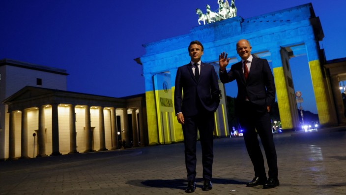 Europäische Union: Am Montagabend machten Emmanuel Macron (li.) und Olaf Scholz einen Ausflug zum Brandenburger Tor, das in den Nationalfarben der Ukraine leuchtete.