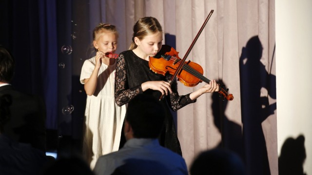 Abend in der Loisachhalle: "Ukrainerland ist abgebrannt": Grundschülerin Anna Schurek begrüßt die Gäste mit einem Kinderlied auf der Geige.