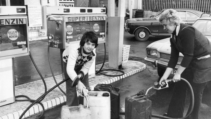 Zeitgeschichte: Hamsterkäufer füllen während der Ölkrise mehrere mitgebrachte Benzinkanister an einer Tankstelle.