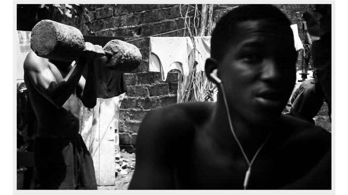 Phototriennale Hamburg: Der eine macht Sport, der andere hört Musik: Fotografie aus dem Bildband "Liberia" (2021) von Andreas Herzau.