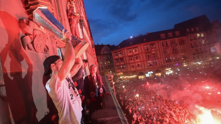 Eintracht Frankfurt: Auf dem Rathausbalkon präsentiert Frankfurts Torwart Kevin Trapp den Fans den Europa-League-Pokal. Unten wird sich um die richtige Ausleuchtung gekümmert.