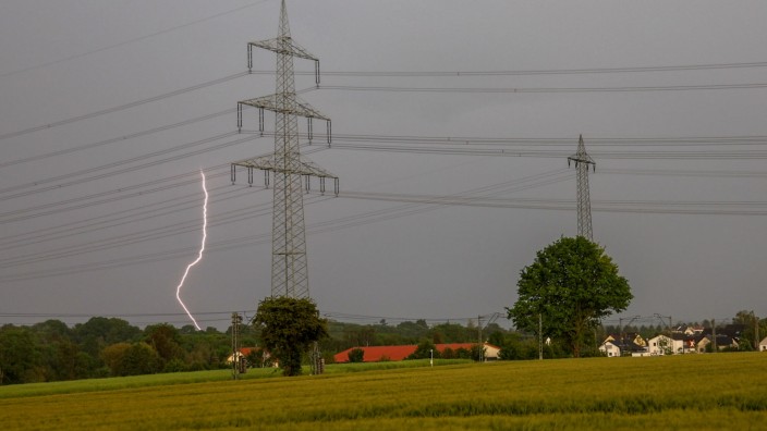 Verhalten bei Unwetter: Ein Blitz schlägt bei einem Gewitter hinter einem Strommast in Frankfurt-Nieder-Eschbach ein.