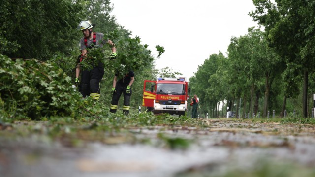 Unwetter: Feuerwehrleute entfernen Trümmer von einer Straße in Lippstadt.