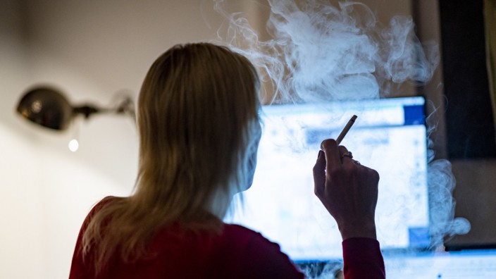 Suchterkrankungen: Eine Frau raucht im Home-Office: Während der Pandemie stieg der Anteil der Raucher.
