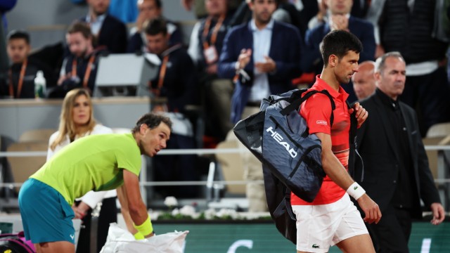 French Open: Da geht er dahin: Während Rafael Nadal noch langsam seine Siebensachen packt, macht sich der enttäuschte - und enttäuschende - Titelverteidiger Novak Djokovic vom Acker.
