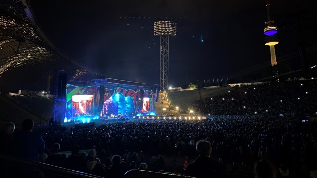 I Rolling Stones a Monaco di Baviera: La Torre Olimpica in giallo e blu sullo sfondo, gli Auguri di Pace sul podio in primo piano.
