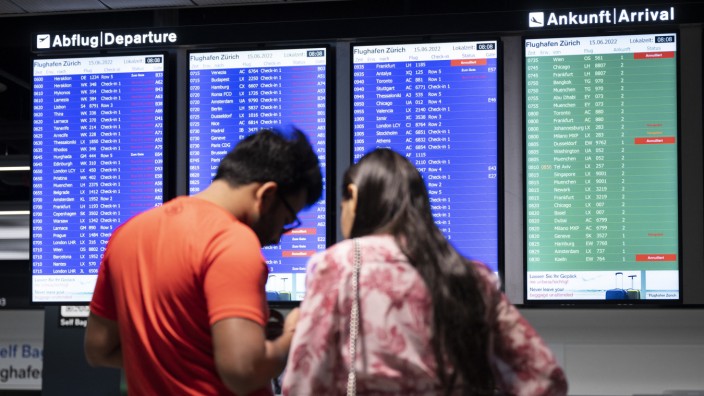 Schweiz: Fluggäste vor einer Anzeigetafel auf dem Flughafen in Zürich