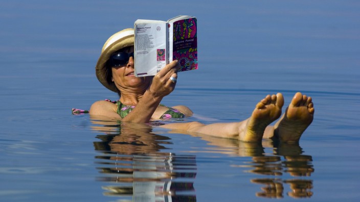 Psychologie: Lesen im Wasser - bei Hitze eine sehr weise Entscheidung, die gewiss auch das Wohlbefinden steigert.
