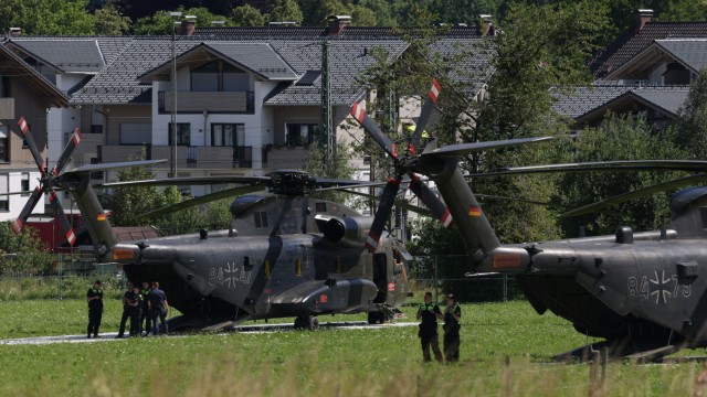 Impressionen rund um den G-7-Gipfel: Polizeibeamte stehen vor Bundeswehr-Helikoptern, die sich auf einem Feld bei Garmisch-Partenkirchen für den Einsatz bereithalten.