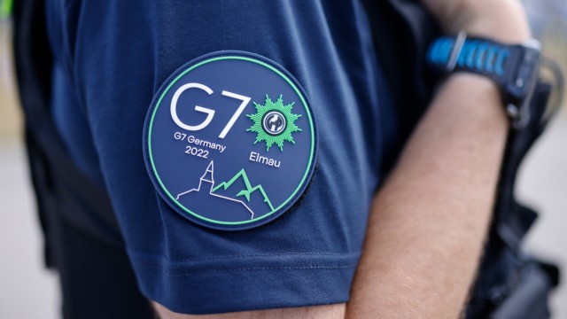 Impressionen rund um den G-7-Gipfel: Polizist mit Gipfel-Logo.