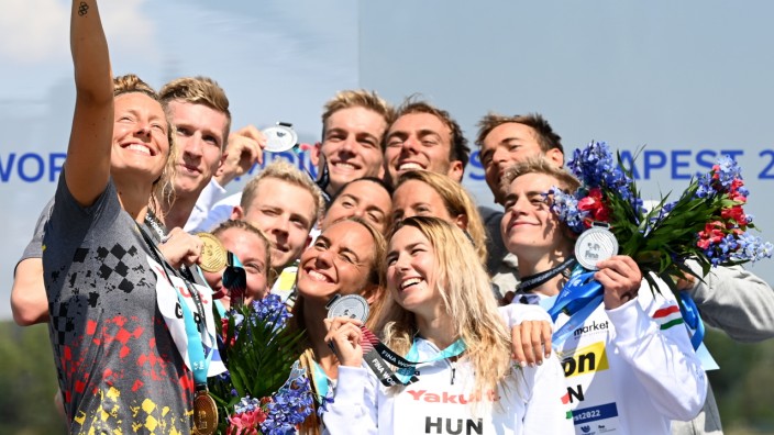 Team-Gold bei der Schwimm-WM: Ziemlich viele Sieger: Selfie-Fotografin Leonie Beck, Florian Wellbrock, Lea Boy und Oliver Klemet feiern (von links) feiern mit den zweitplatzierten Ungarn und Bronzegewinner Italien ihren Freiwasser-Titel.