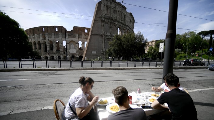 Euro-Krise: Es ist Sommer in Italien, und überall sitzen Menschen auf der Piazza - so wie hier gegenüber dem Kolosseum. Die Frage ist: Kommt bald schon eine neue Euro-Krise?