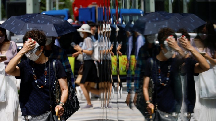 Stromsparen in Japan: Schon frühmorgens auf dem Weg zur Arbeit müssen sich die Menschen in Tokio den Schweiß von der Stirn wischen - so heiß ist es.