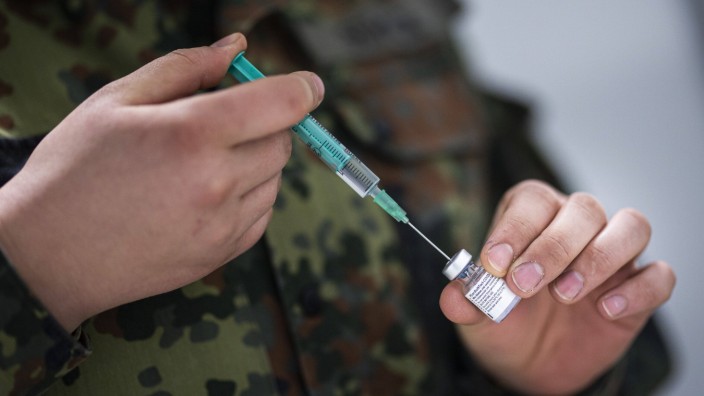 Coronavirus-Pandemie: Eine Soldatin zieht eine Spritze mit dem Corona-Impfstoff von Biontech und Pfizer auf.