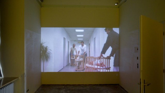 Ausstellungsreihe "Transformationen": "Was wäre, wenn sich alle Mütter nach der Geburt in ihren Zimmern einfach nur erholen dürften (...)?", fragt Künstlerin Gabi Blum und schickt in ihrem Video die Väter mit den Neugeborenen los.