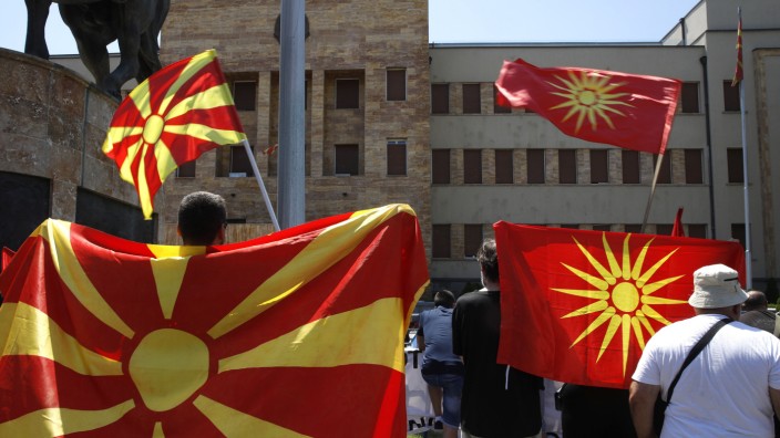 Nordmazedonien: Demonstranten protestieren in Skopje mit der aktuellen (links) und der alten Nationalfahne gegen den Kompromissvorschlag im Streit mit Bulgarien.
