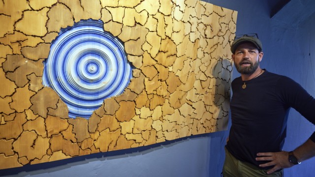"Weltkunst" an der Isar: Daniel Fuchs vor einem frisch gehängten Holzmosaik in der Säggasse.
