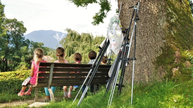 Sommerferien in München: Beim Malen im Freien kann man die Staffelei auch einmal beiseite stellen und nur den Blick auf Murnau und die Berge genießen.