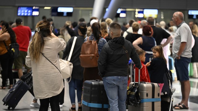 Luftverkehr: Reisende stehen in Schlangen vor den Check-in-Schaltern am Flughafen Düsseldorf.