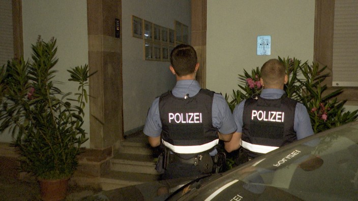 Saarbrücken: Polizeibeamte stehen vor einem Hauseingang in Saarbrücken. Hier ist am Donnerstagabend eine Dreijährige bei einem Sturz so schwer verletzt worden, dass sie starb.
