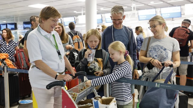Münchner Flughafen: Gabriele Koch von der Aichner Ambulanz Union verteilt Gummibärchen und Getränke an wartende Fluggäste.