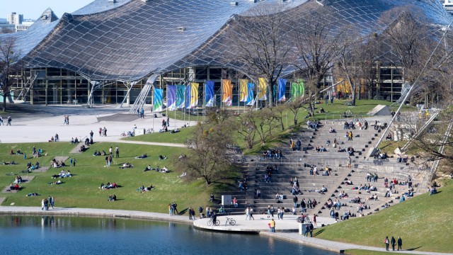 European Championships in München: Zahlreiche Menschen genießen das schöne Wetter im Olympiapark. Im Hintergrund ist das Dach der Olympiahalle zu sehen.