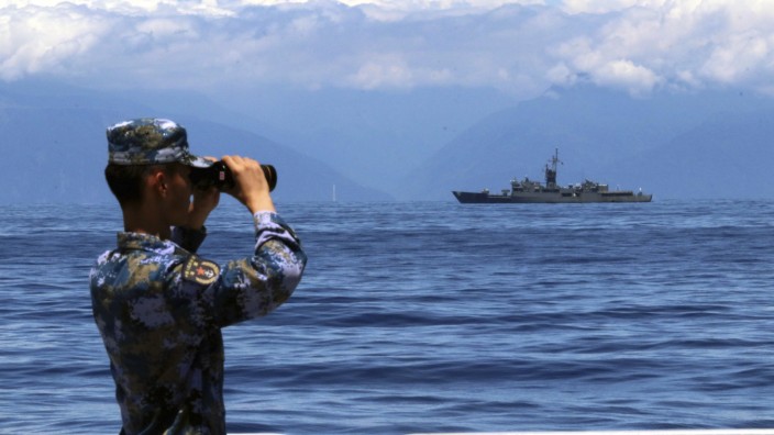 Manöver: Das von der chinesischen Nachrichtenagentur Xinhua veröffentlichte Foto zeigt einen Soldaten der chinesischen Volksbefreiungsarmee, während im Hintergrund Taiwans Fregatte Lan Yang zu sehen ist.