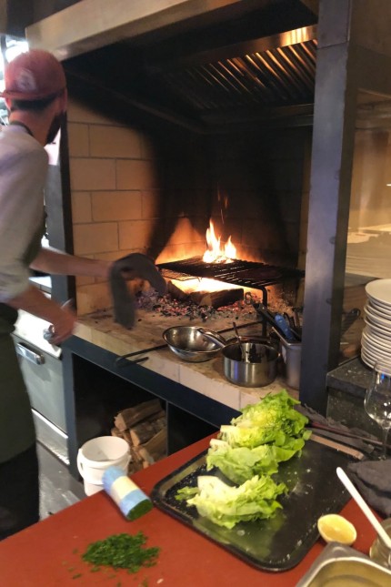 Stubn in der Frasdorfer Hütte: Die Küche ist im offenen Showformat gestaltet, das Holzfeuer vom Gastraum gut einsehbar.