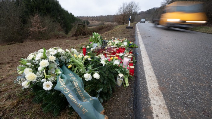 Prozess um Polizistenmorde in Kusel: Blumen und Kerzen stehen an dem Tatort, an dem Ende Januar 2022 bei Kusel zwei Polizeibeamte bei einer Verkehrskontrolle erschossen wurden.