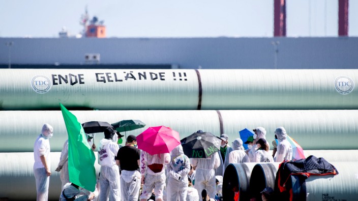 "Ende Gelände": Aktivisten stehen am Freitag vor gelagerten Rohrleitungen auf der Baustelle für die geplante Gaspipeline in Wilhelmshaven.
