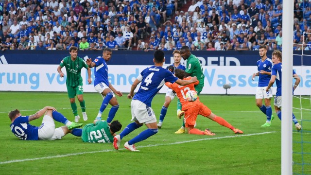 Schalkes erster Punktgewinn: Torwart Alexander Schwolow kommt raus und kann den Ball nicht klären, Marcus Thuram bedankt sich.