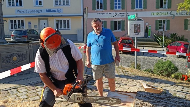 1. Künstlersymposium Altomünster: Holzbildhauer Clemens Heinl bringt Altomünsters Bürgermeister Michael Reiter ganz schön ins Schwitzen. Die Arbeit an der Kettensäge ist anstrengend.