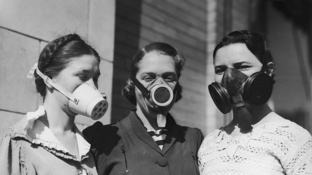 Historie: Masken 1935: Junge Frauen versuchen, sich vor dem allgegenwärtigen Staub zu schützen, der Lunge und Atemwege angreift.
