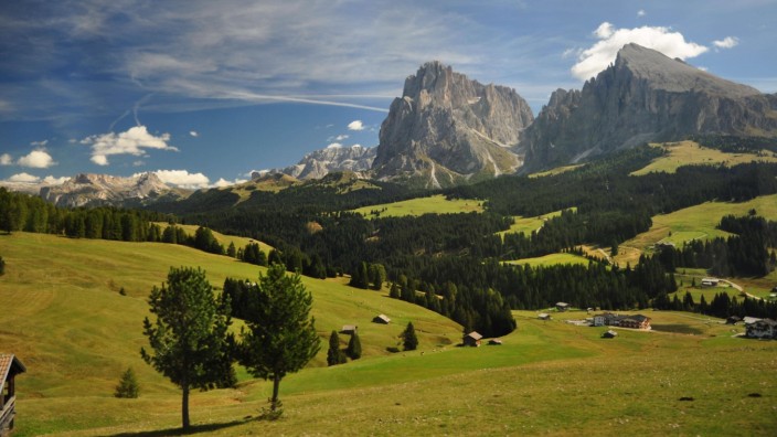 Südtirol: Die Seiser Alm in den Südtiroler Dolomiten gilt als die größte Hochalm Europas. Ein Netz von Wanderwegen erschließt das Gebiet. Bergsportlerinnen und Bergsportler haben stets das grandiose Bergpanorama - hier von Langkofel und Plattkofel - im Blick.