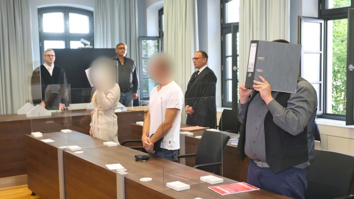 Flughafen Memmingen: Eine Jugendliche (links) und ein Erwachsener (rechts) stehen zum Prozessbeginn im Gerichtssaal des Landgerichtes Memmingen in der Anklagebank. In der Mitte der Vater der jugendlichen Angeklagten. Den Beschuldigten wird vorgeworfen, gemeinsam eine 16-Jährige getötet zu haben.