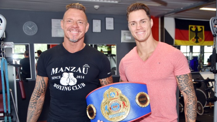 Boxer aus Olching: Michael Manzau (links) präsentiert den gewonnenen WBF-Titel in in seinem Olchinger Box- und Fitnessstudio, in dem auch sein Sohn Tom arbeitet.