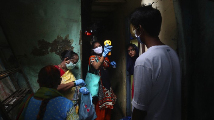 Impfstoffe: Eine Helferin untersucht Einwohner von Mumbai auf Symptome von Covid-19. Indien setzt zur Immunisierung nun auch auf einen Nasenimpfstoff.