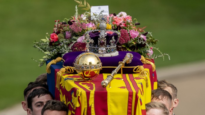 Elizabeth II.: London am 19. September: Die Sargträger tragen den in die königliche Standarte gehüllten Sarg von Königin Elizabeth II. mit der Krone, dem Reichsapfel und dem Zepter.