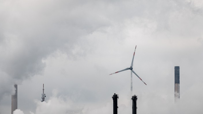 Verstaatlichung: Ein Windrad steht im Dampf von Kraftwerken: Der Staat wird demnächst zum Eigentümer des Energieunternehmens Uniper.