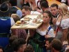 Oktoberfest München Kellnerin balanciert ein volles Tablett mit Speisen im vollbesetzten Festzelt H