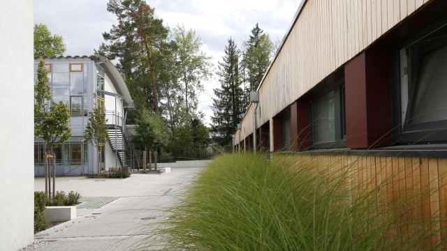 Holz, Glas, Beton: Die holzverkleideten Fassaden am Neubau der Isardammschule (rechts) spielen mit den architektonischen Ideen der skandinavischen Moderne.