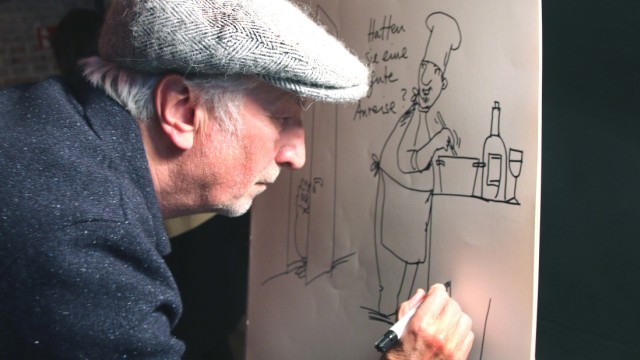 Gründungsfeier: Mitten im Partytrubel fertigt der Karikaturist Peter Gaymann eine seiner Zeichnungen mit Huhn an.