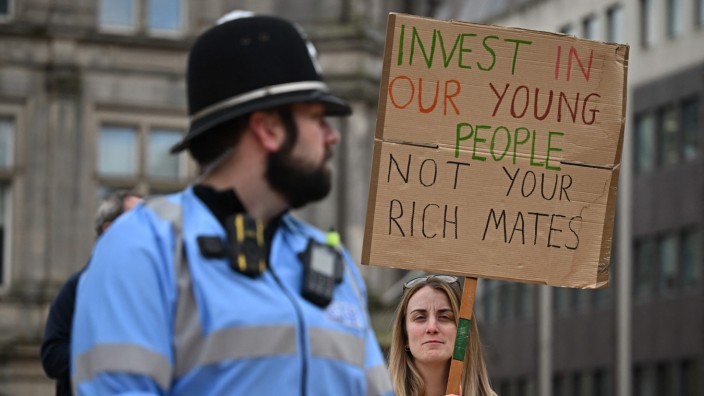 Großbritannien: Eine Frau protestiert in Birmingham, wo die Konservative Partei von Großbritannien ihren Parteitag abhält. "Investiert in unsere Jugend statt in eure reichen Freunde", steht auf ihrem Plakat.