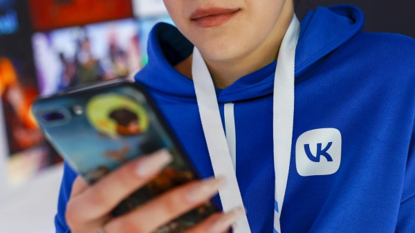 Social Media: Person mit Handy und einem VK-Sweatshirt