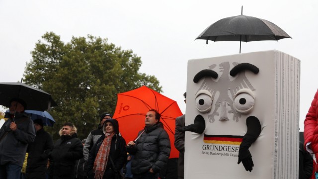 Das Politische Buch: Das Grundgesetz und sein Regenschirm: Szene vom Tag der Deutschen Einheit 2022 in Erfurt.
