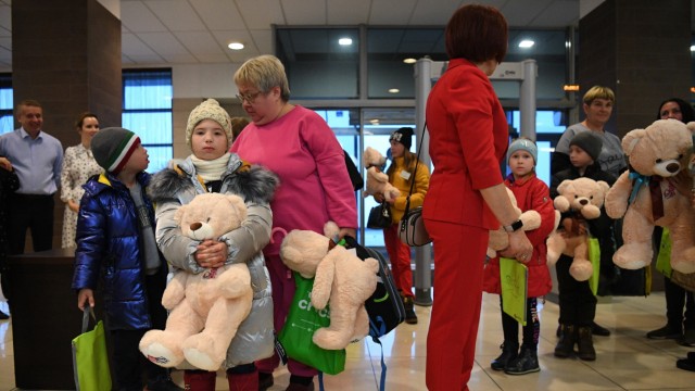 Russland: Am Flughafen im russischen Nowosibirsk werden Kinder aus der ukrainischen Region Luhansk mit Teddybären begrüßt.